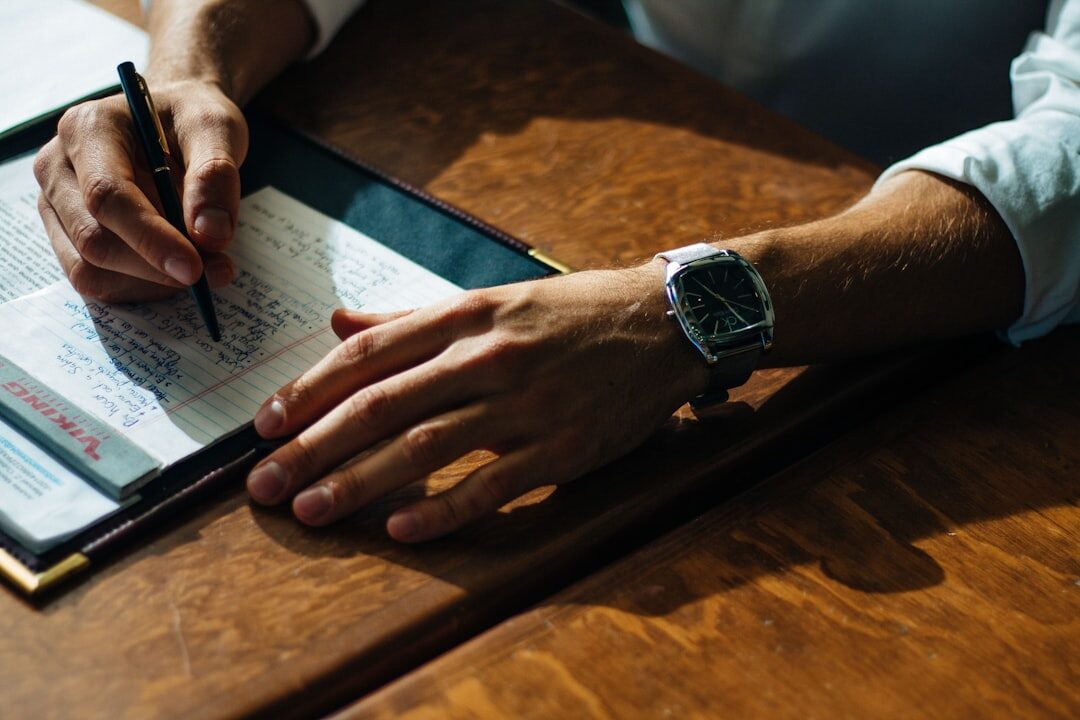 Journalist taking handwritten notes next to a tablet with articles